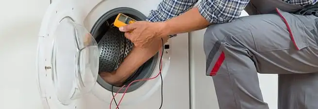 Dryer repair technician inspecting and repairing a clothes dryer in Houston, TX