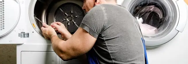 Dryer repair technician fixing a clothes dryer drum in Houston, TX