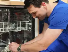 Dishwasher repair technician inspecting and servicing an open dishwasher in Houston, TX
