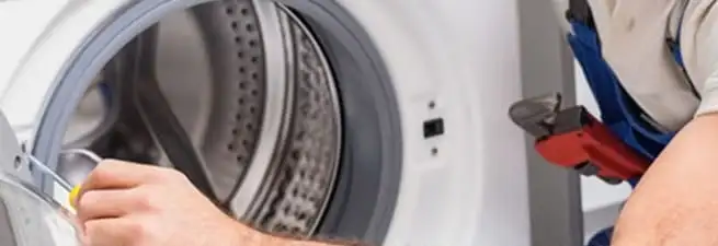 Appliance technician repairing a clothes dryer drum and internal parts in Houston, TX