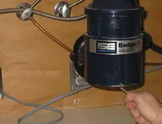 Garbage disposal repair technician tightening the mounting ring under a sink in Houston, TX