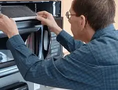 Appliance repair technician replacing a microwave vent filter in Houston, TX