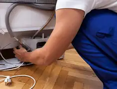 Appliance repair technician fixing refrigerator water line and connections in Houston, TX