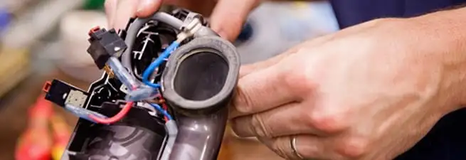 Vacuum repair technician reconnecting wiring and components in Houston, TX