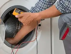 Washing machine repair technician testing a front-load washer with diagnostic tools in Houston, TX