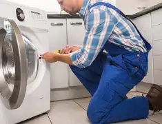 Washing machine repair technician servicing a front-load washer in Houston, TX