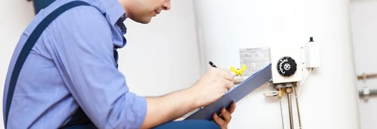 Water heater repair technician inspecting the unit and recording service notes in Houston, TX