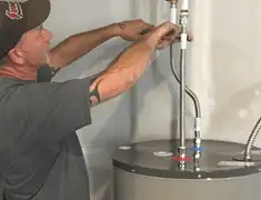 Water heater repair technician tightening supply line connections in Houston, TX